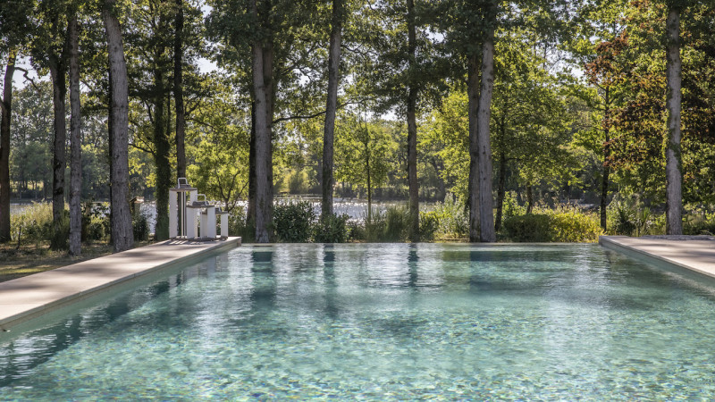 Piscine à paroi de verre Piscine In&Out 3D Grège / Au soleil ou sous la pluie : piscine in out paroi verre vue lac foret exterieur esprit piscine 2022